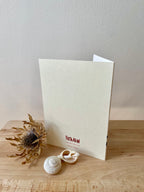 Bateleur Eagle greetings card -- back of a greeting card with 'Freya Allan' branding on a wooden surface with decorative elements.