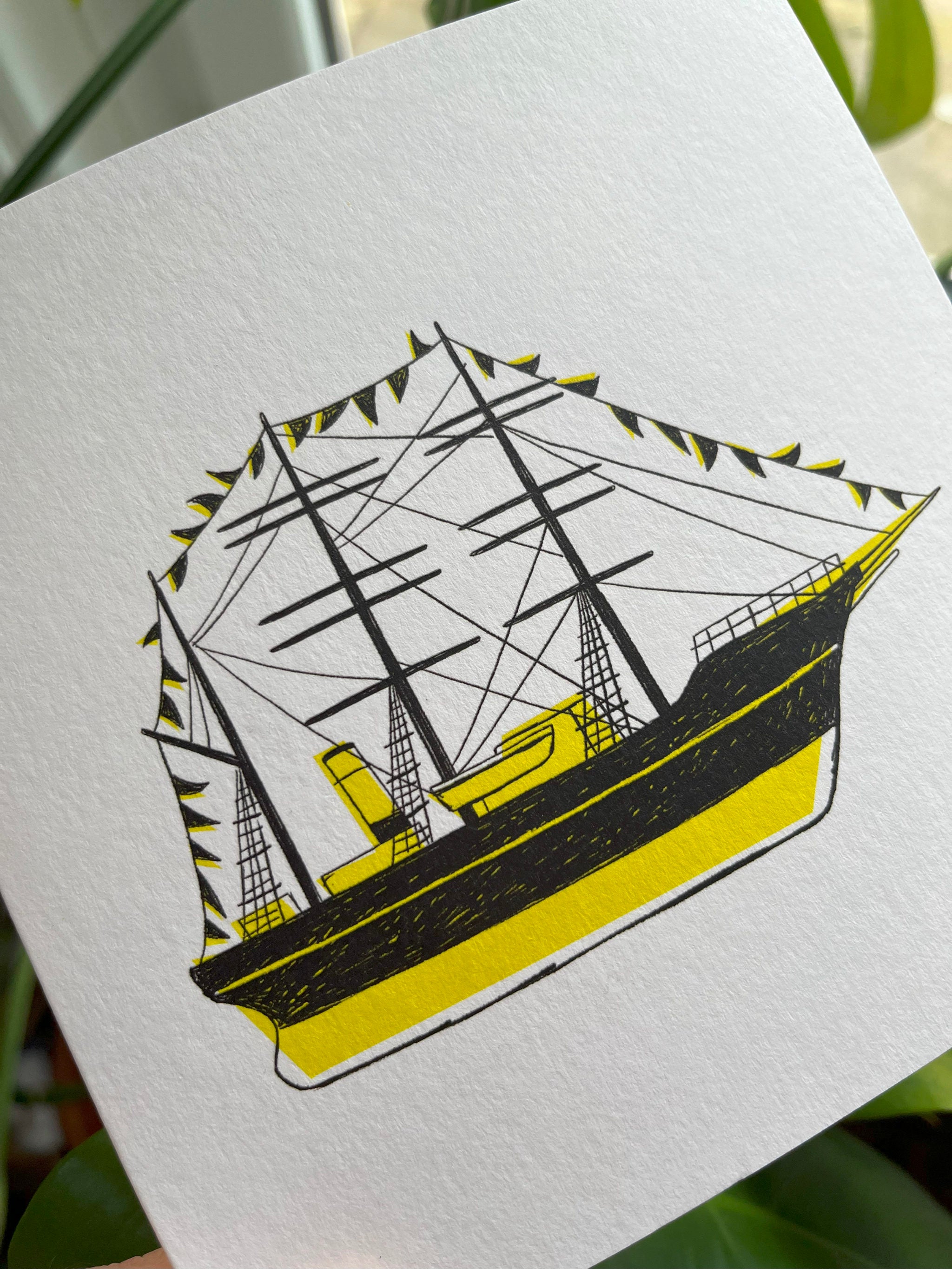 Discovery greetings card -- close-up of an illustration of a ship on a white card with a yellow bottom.