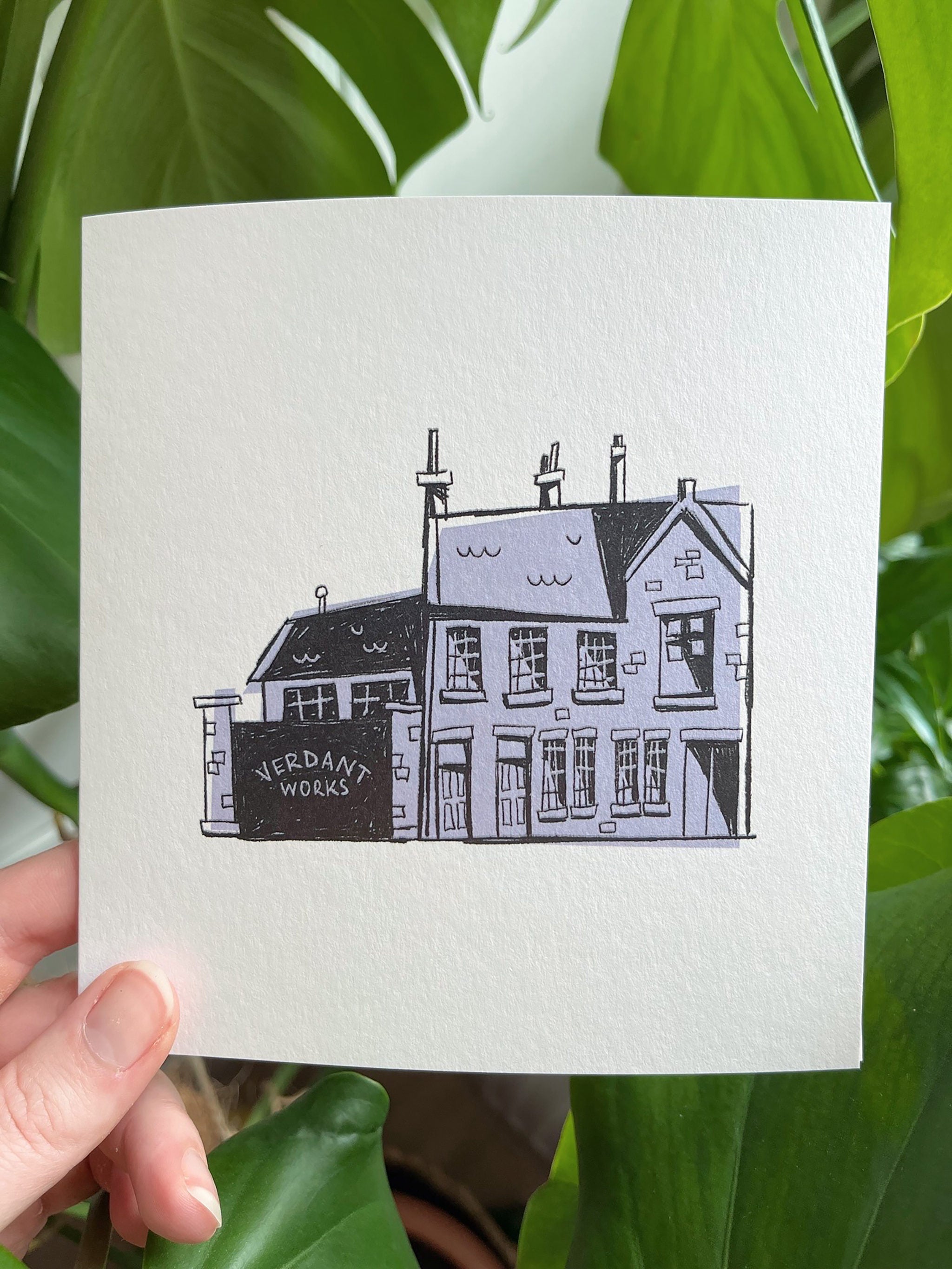 Verdant Works greetings card -- handheld card with a black and white illustration of a building labeled 'Verdant Works' against a green leafy background.