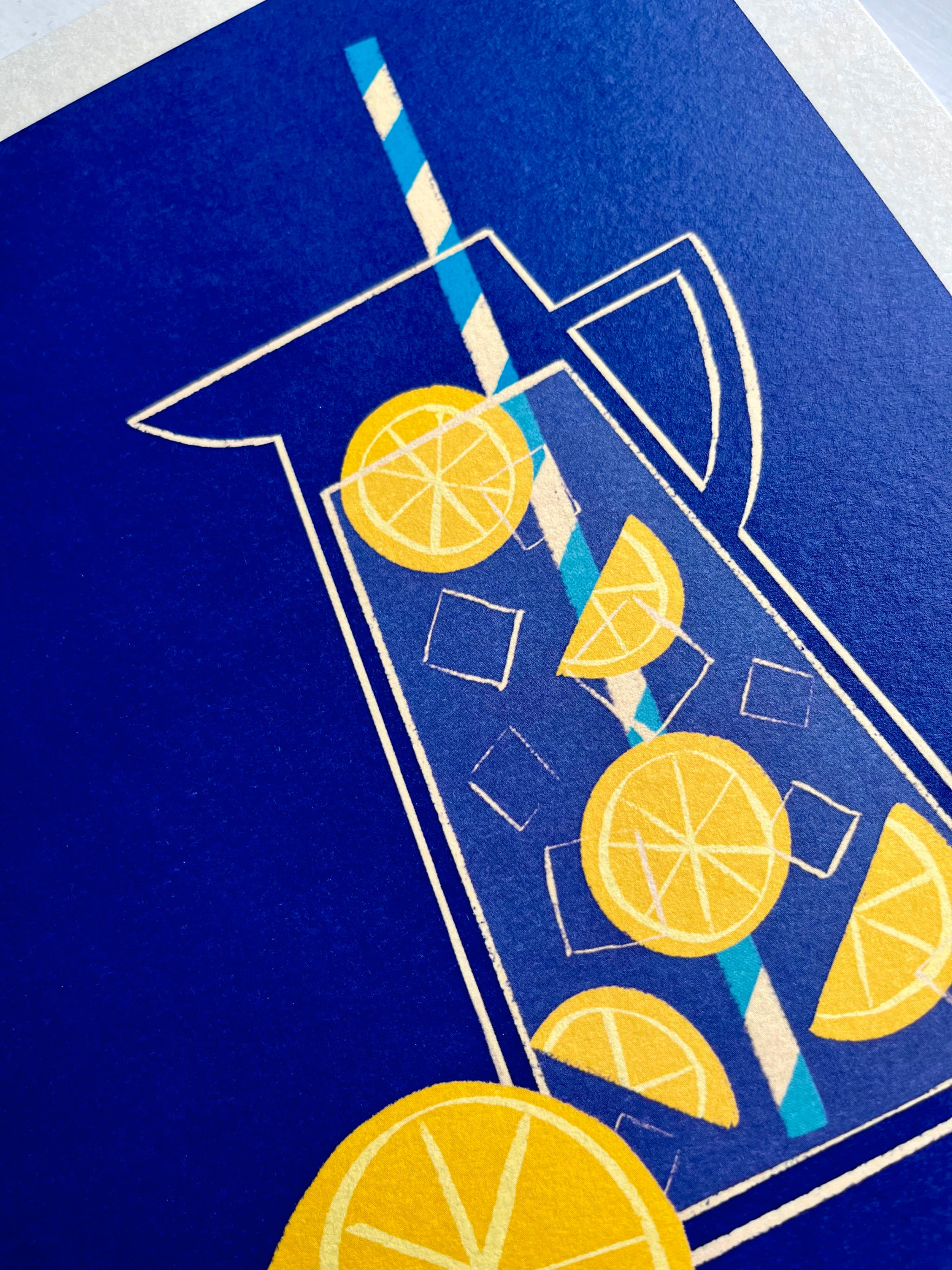 Lemonade print -- close-up of an illustration of a glass with lemons and a straw on a blue background.
