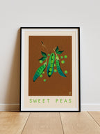 Sweet Peas print -- framed artwork of sweet peas on a brown background with 'Sweet Peas' text, leaning against a white wall.